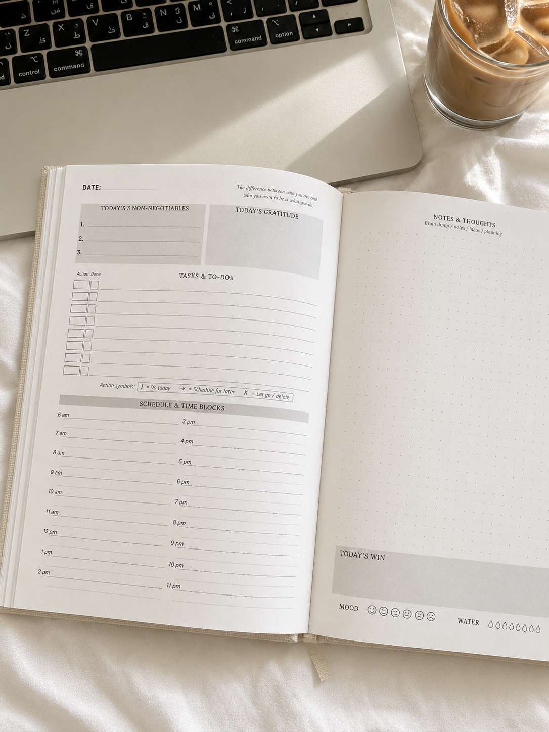Daily planning spread beside a laptop and iced coffee