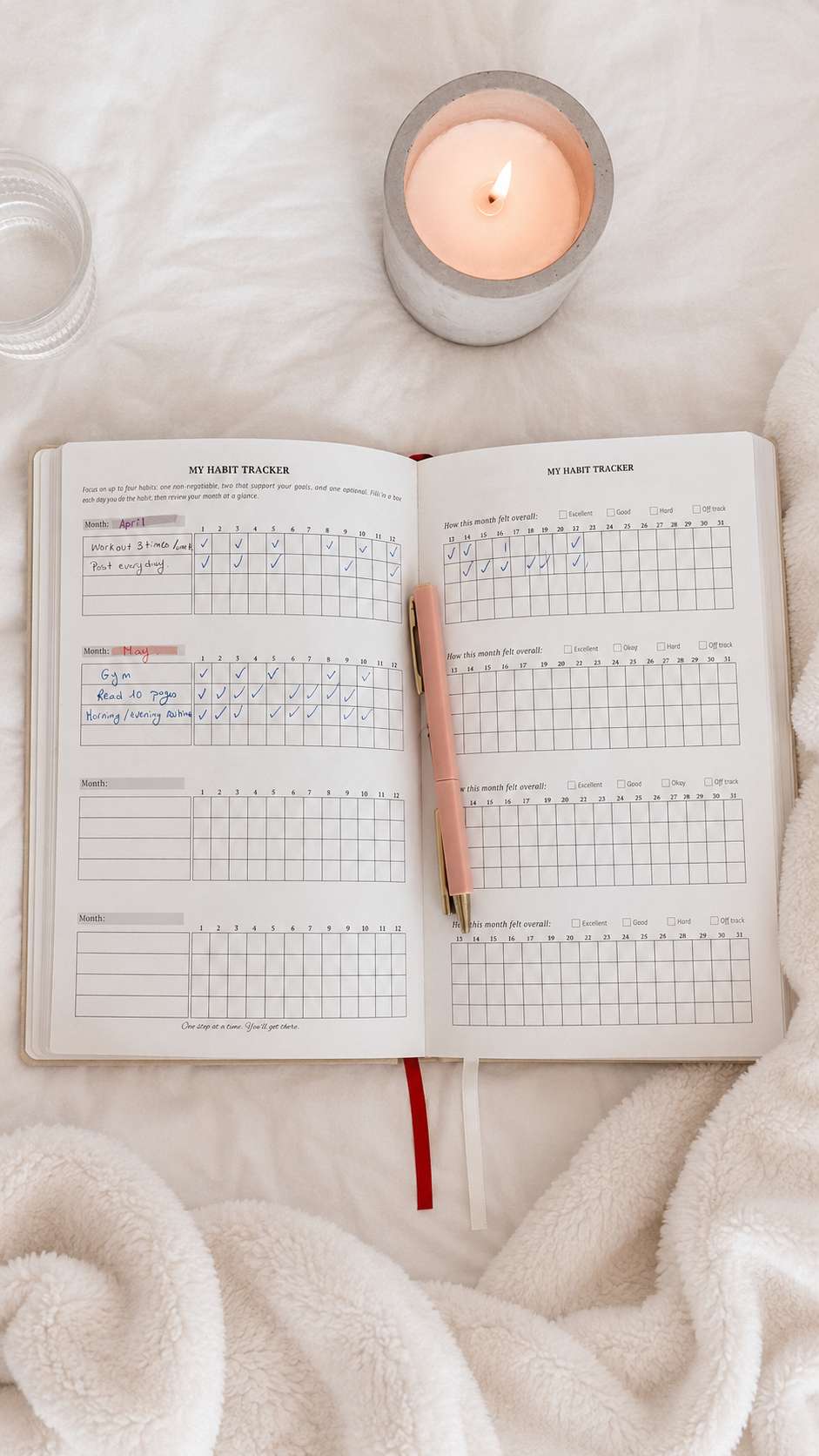 Filled habit tracker spread beside a candle and pen