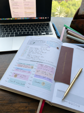 Close-up of planner pages with written tasks