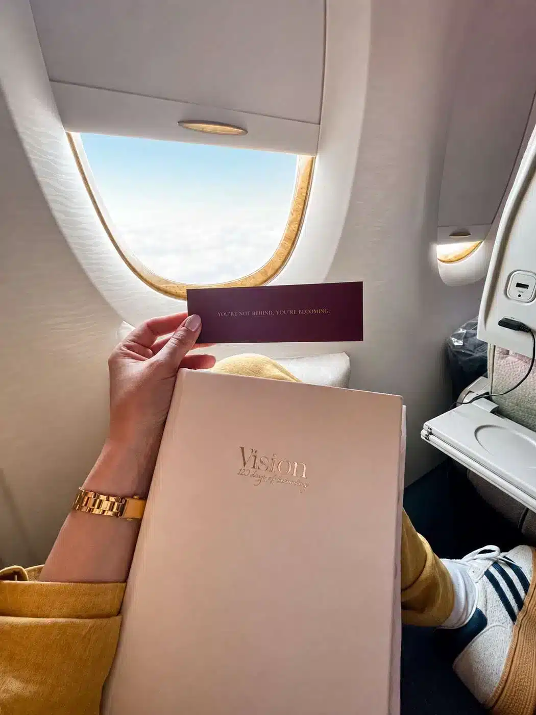 Customer traveling with her VisionRuya planner, holding the You are not behind, You are becoming card